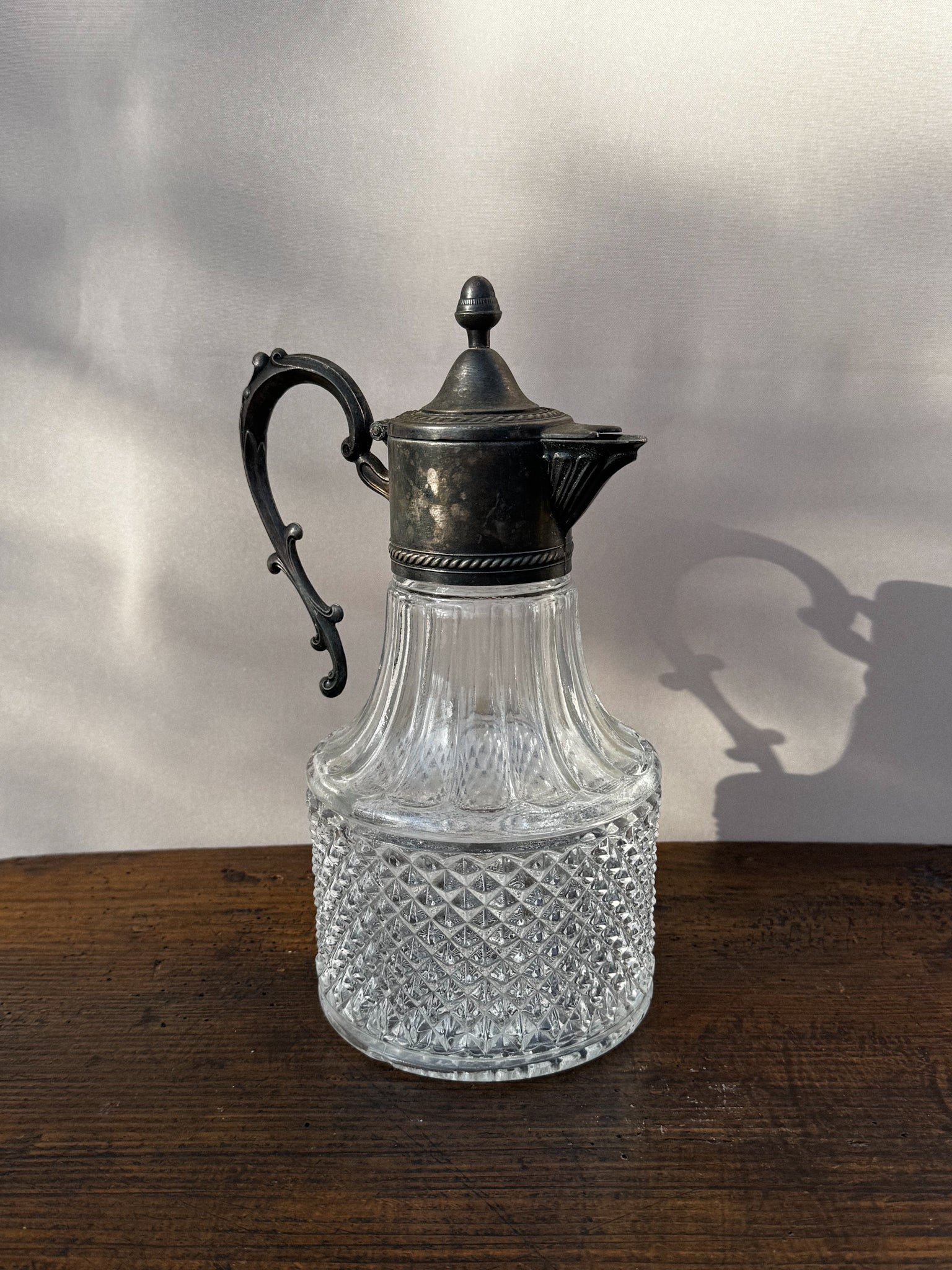 Skleněná karafa s kovovým víčkem a uchem