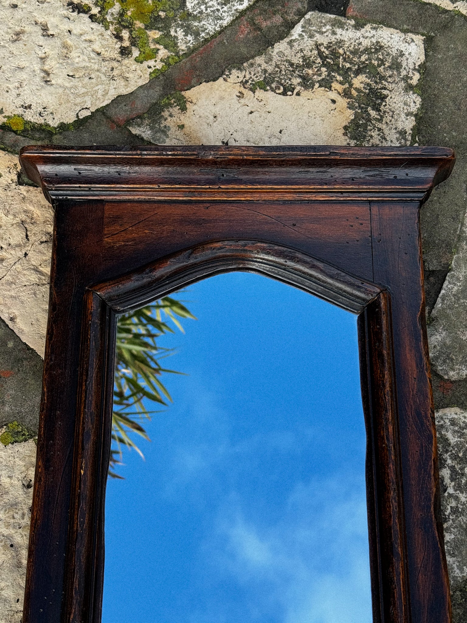 Starožitné zrcadlo v dřevěném rámu s tvarovaným horním profilem 19. století