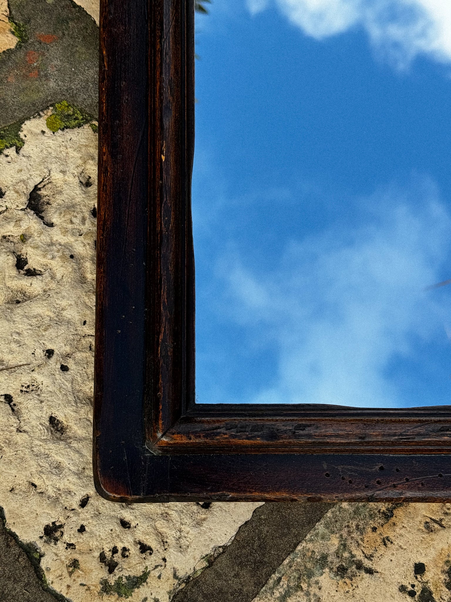 Starožitné zrcadlo v dřevěném rámu s tvarovaným horním profilem 19. století