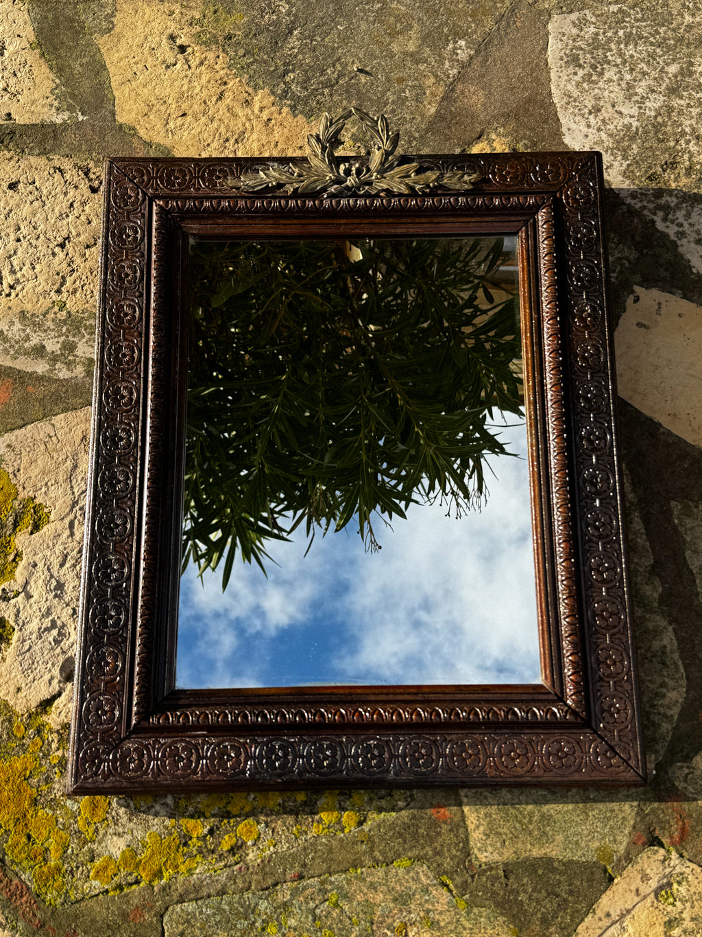 Starožitné zrcadlo s bohatě zdobeným rámem a horním ornamentem