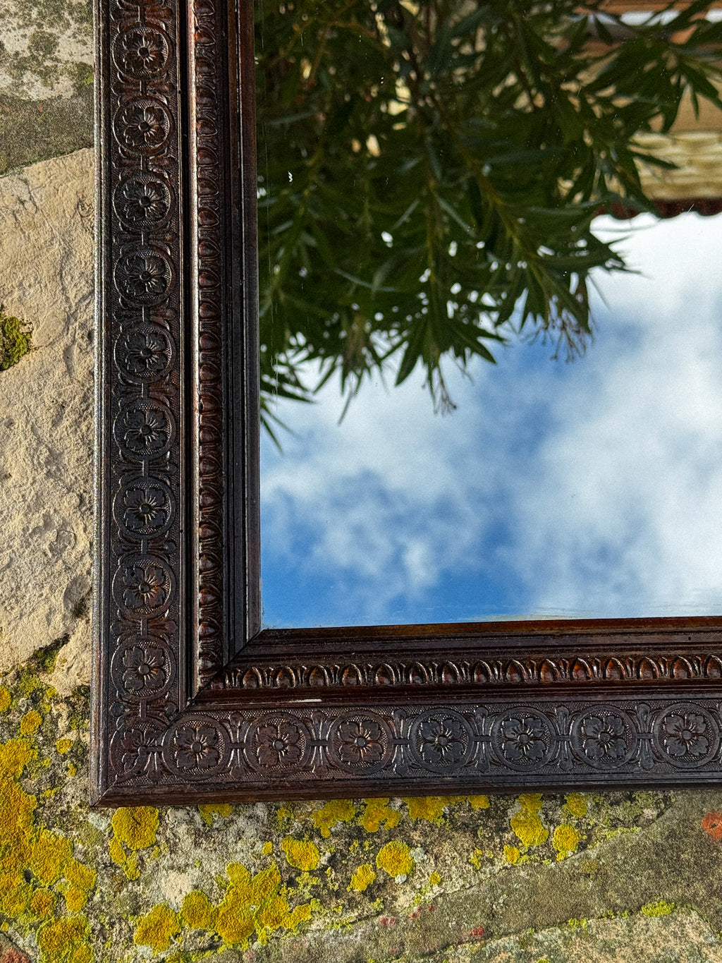 Starožitné zrcadlo s bohatě zdobeným rámem a horním ornamentem