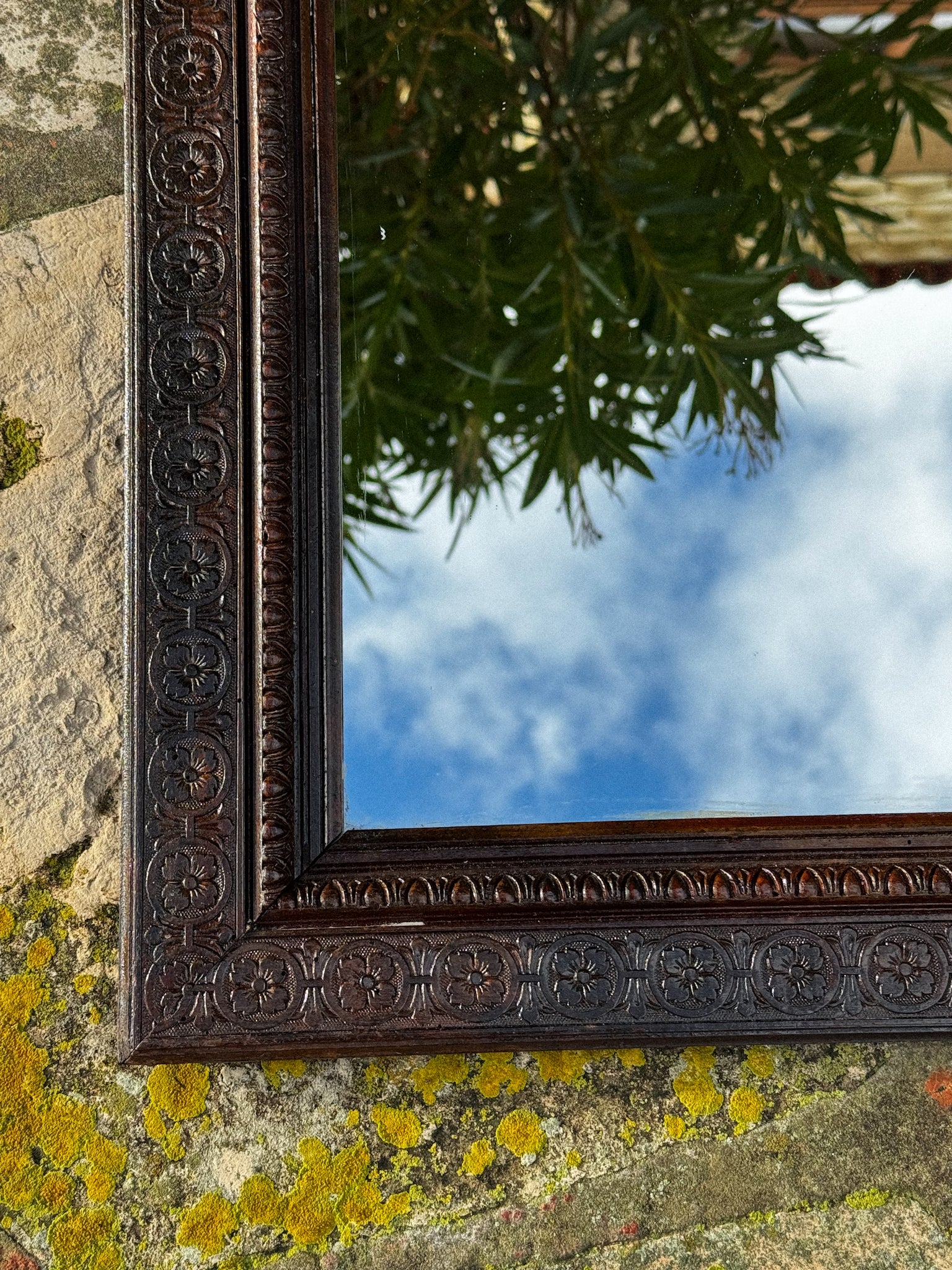 Starožitné zrcadlo s bohatě zdobeným rámem a horním ornamentem