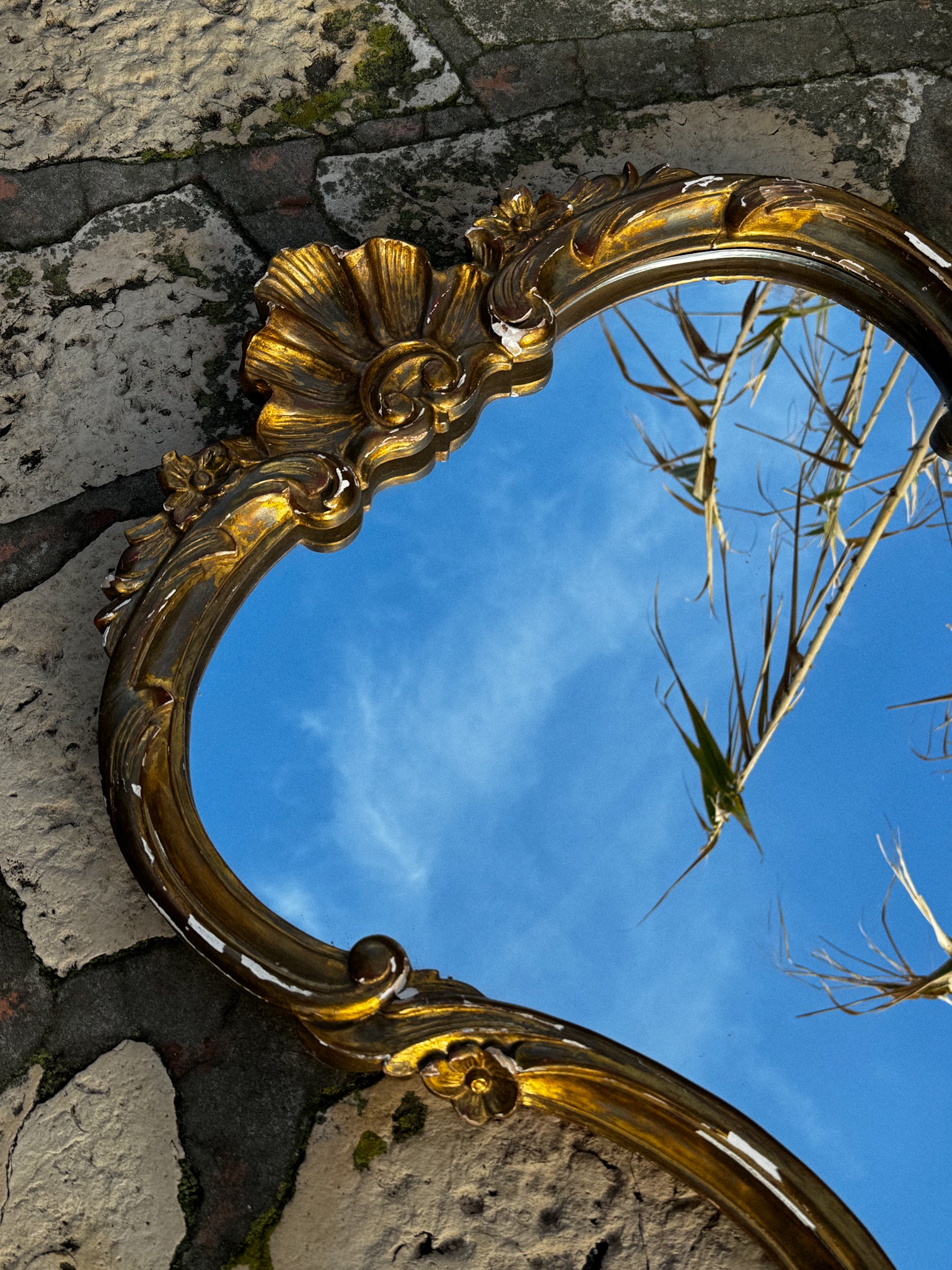 Velké starožitné zrcadlo ve zdobené rámu zlaté barvy