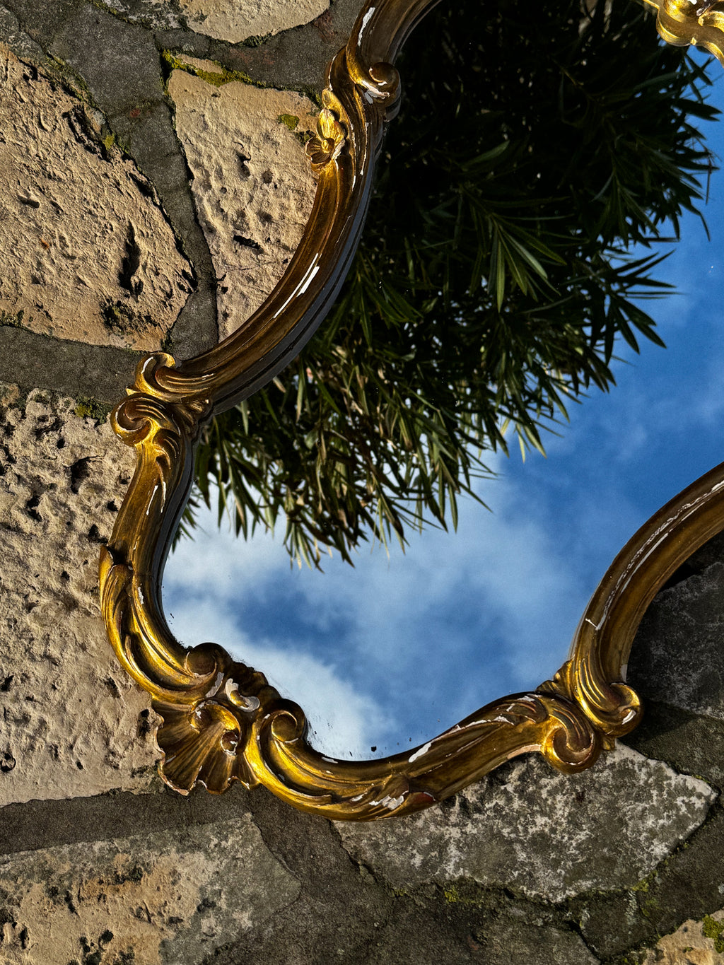 Velké starožitné zrcadlo ve zdobené rámu zlaté barvy